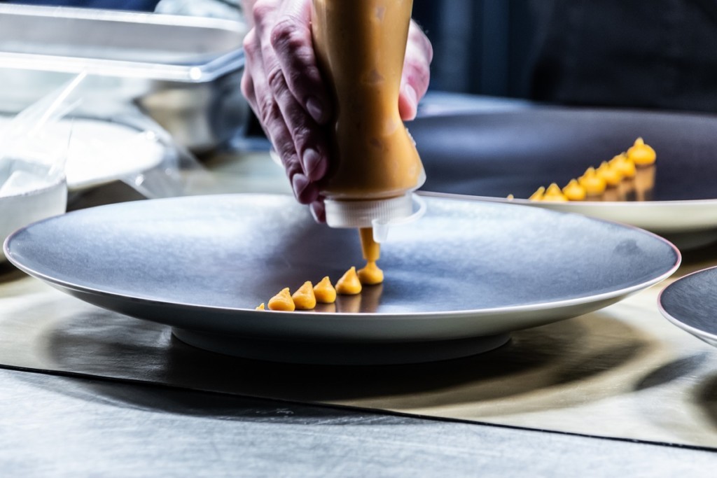 Habiller une assiette au restaurant Taste à Louvain